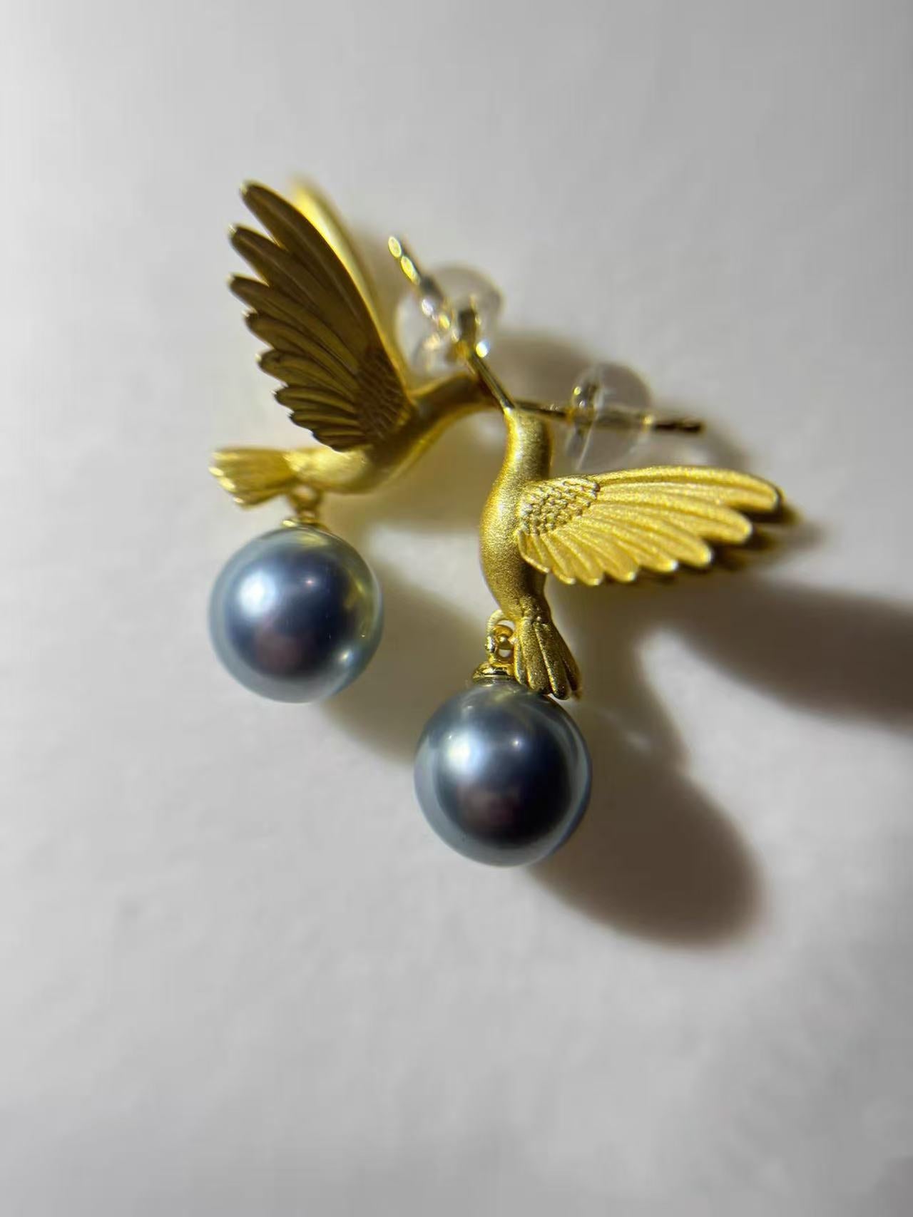 “A mist on the sea where the hummingbirds fly” Handmade gold and silver carved hummingbird pearl earrings